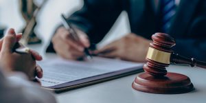 person signing papers and a gavel